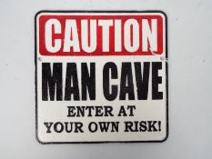 A cast iron wall plaque marked Caution Man Cave Enter At Your Own Risk!, 25 cm x 25 cm,