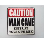 A cast iron wall plaque marked Caution Man Cave Enter At Your Own Risk!, 25 cm x 25 cm,