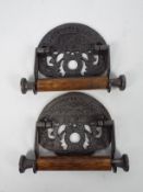 A pair of cast iron and wood toilet roll holders marked St Pancras Fixture,