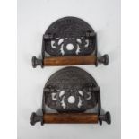 A pair of cast iron and wood toilet roll holders marked St Pancras Fixture,