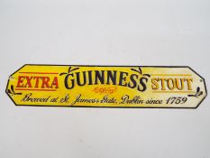 A cast iron wall plaque marked Guinness Extra Stout, 13 cm x 56 cm,