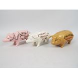 Three cast iron pig money banks, approximately 19 cm (l),