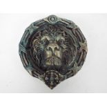 A cast iron door knocker in the form of a lion's head, approximately 21 cm (d),