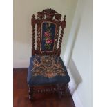 A highly carved chair with upholstered seat and back rest.