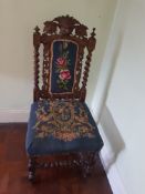 A highly carved chair with upholstered seat and back rest.