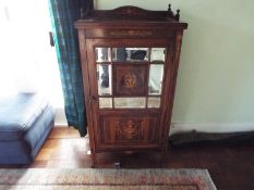 A cabinet with inlaid decoration and mirrored door opening to reveal four shelves,