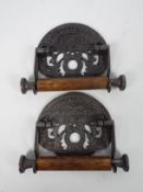 A pair of cast iron and wood toilet roll