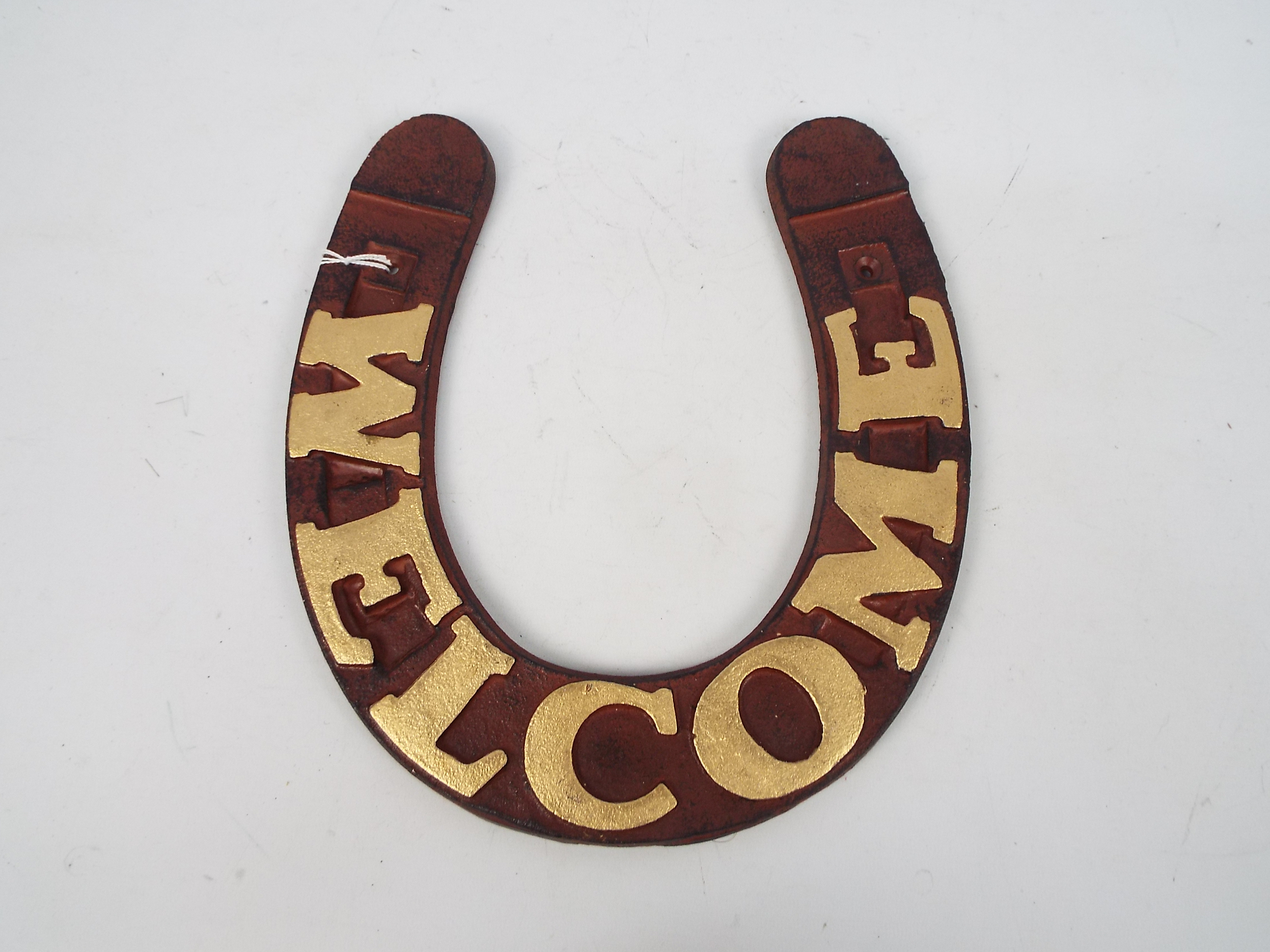 A cast iron, horseshoe shaped Welcome si