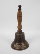 A cast iron hand bell with wooden handle