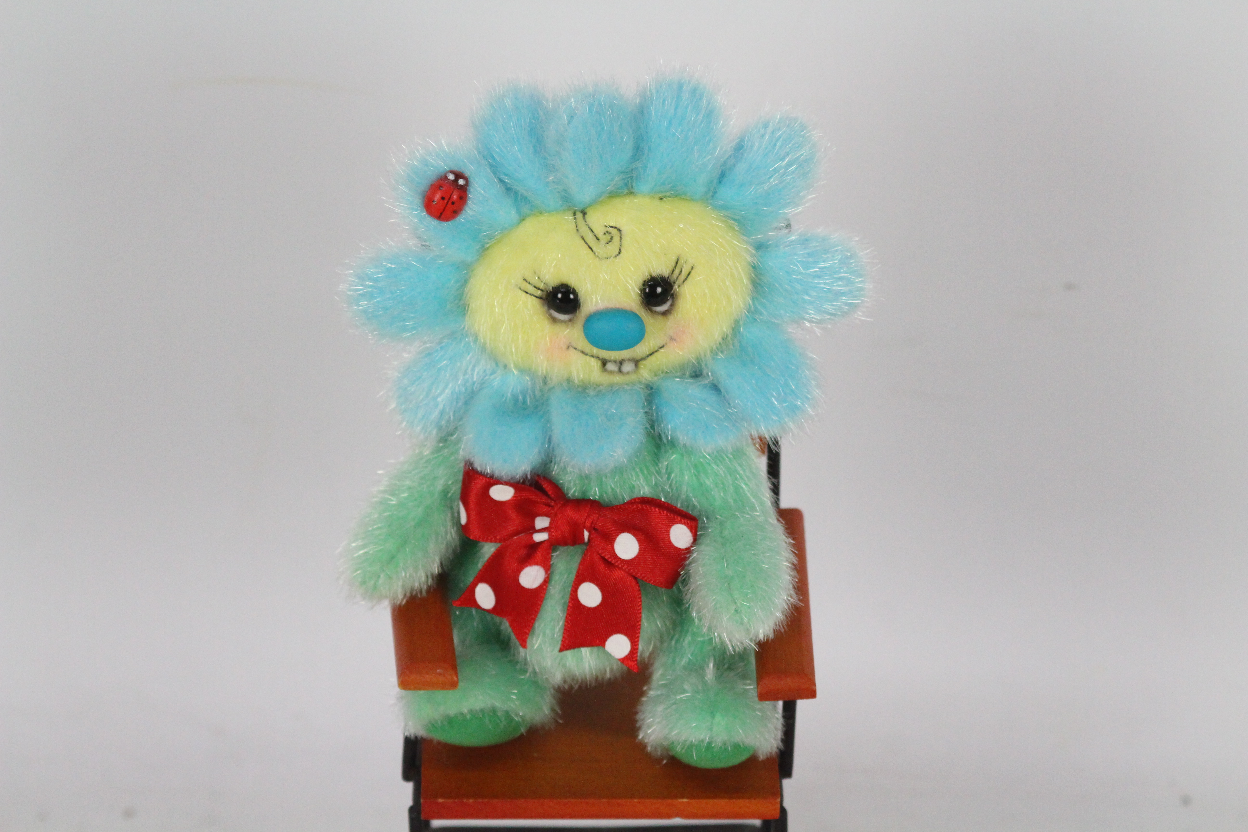 A soft toy in the form of a flower, soft toy has a red bow and a plastic lady bird accessory. - Image 2 of 4