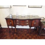 A sideboard having twin drawers flanked by single door cupboards with protective glass top,