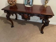 A highly carved table measuring approximately 83 cm x 142 cm x 69 cm.