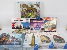 A collection of boxed jigsaw puzzles to include three Ravensburger 3D puzzles,