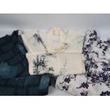 A collection of traditional Japanese clothing to include a silk kimono decorated with chrysanthemum.