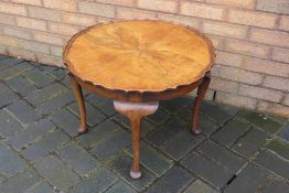 A walnut occasional table with shaped circular top, raised on cabriole supports,