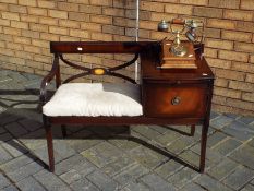 A mahogany Chippy telephone table, approximately 69 cm x 97 cm x 46 cm and a wood cased telephone.
