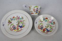 A cup, saucer and plate decorated with figures in a garden setting, unmarked to the base,