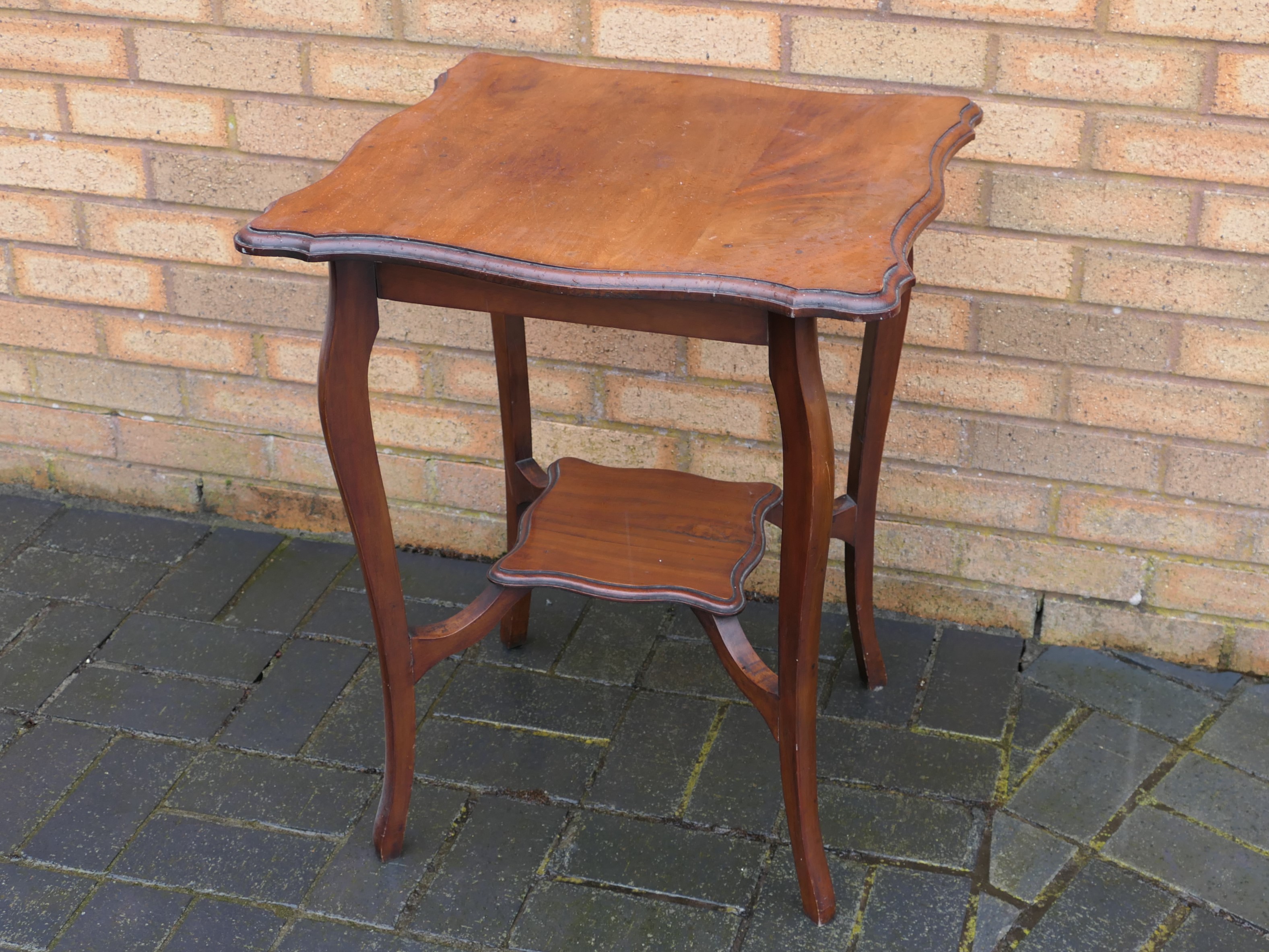 A side table with undertier and shaped top, approximately 71 cm x 53 cm x 55 cm.