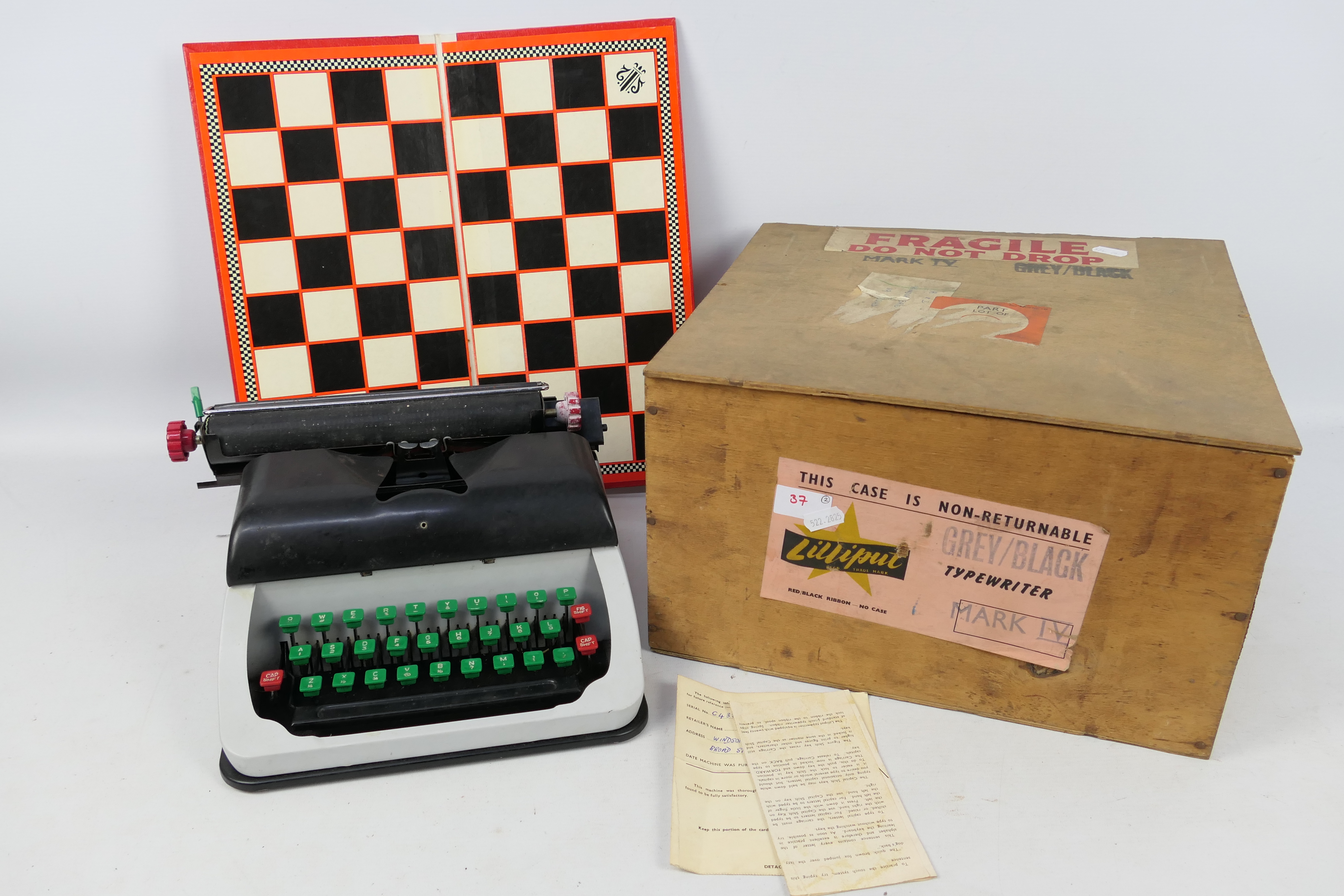 A Lilliput Mark IV typewriter contained in shipping crate and a folding chess board.