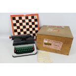 A Lilliput Mark IV typewriter contained in shipping crate and a folding chess board.