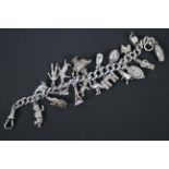 A silver charm bracelet, 19 cm (l), with 19 various charms,