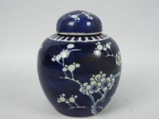 A blue and white ginger jar and cover, decorated in prunus, vacant double circle mark to the base,