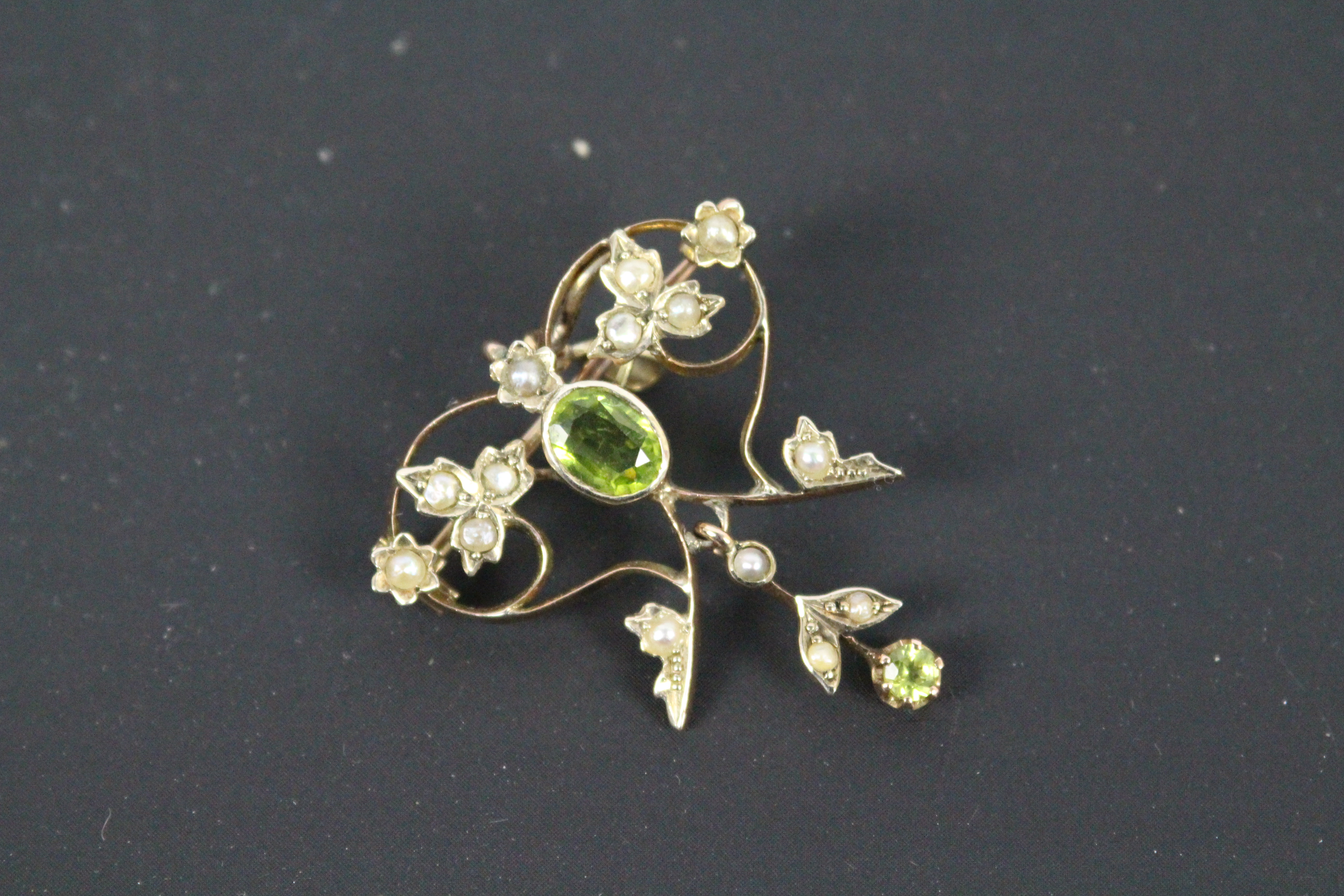 A yellow metal, peridot and seed pearl pendant / brooch, unmarked (presumed 9ct), approximately 3.