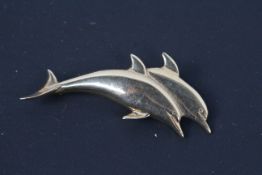 A 9ct yellow gold brooch in the form of two dolphins, 5.5 cm (l), approximately 8.4 grams.