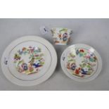 A cup, saucer and plate decorated with figures in a garden setting, unmarked to the base,