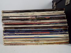 A collection of 12" vinyl records to include ELO, David Bowie, The Monkees, The Jam,
