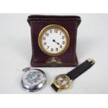 A vintage German travel clock in leather pouch, Russian pocket watch and a wrist watch.
