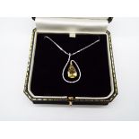 A yellow Beryl and white Diamond pendant with white metal chain stamped 18K (18 carat),