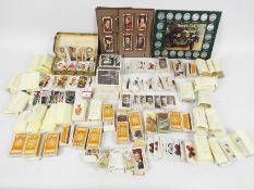 A collection of varied cigarette cards, largely organised into sets and a Historic Cars coin set.