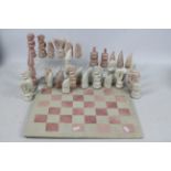 A carved stone chess set and board, 11.