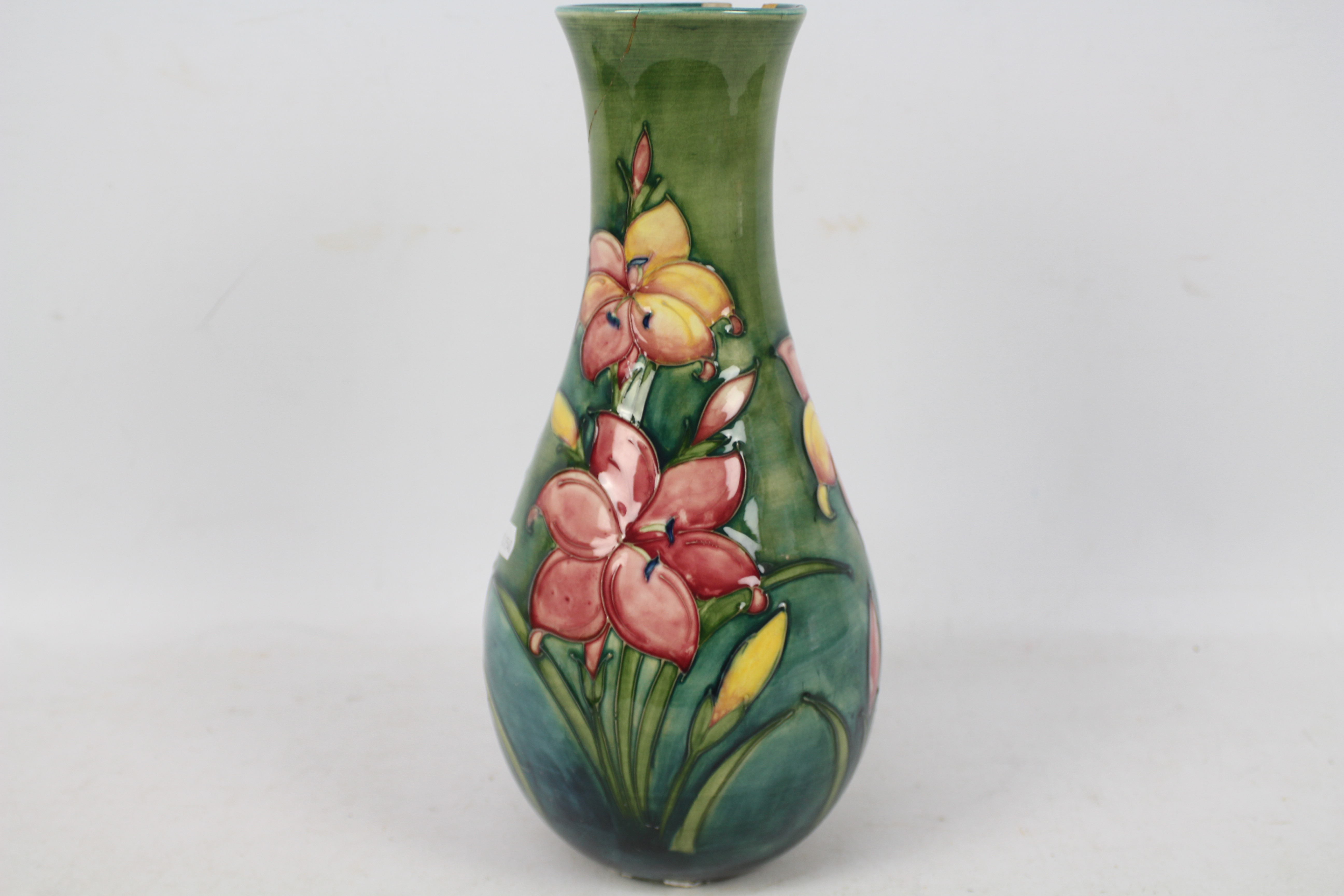 Moorcroft - A Moorcroft pottery baluster vase decorated in the Freesia pattern against a green