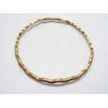 A 9ct gold bangle of undulating form, 7 cm (d), 9.5 grams.