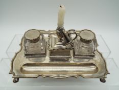 An Edward VII hallmarked silver desk set comprising candleholder with snuffer flanked by twin glass