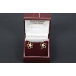 A pair of diamond and unmarked yellow metal (presumed 9ct) ear studs in the form of flower heads,