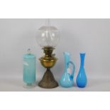 A brass and cast iron oil lamp, 54 cm (h) and three pieces of blue glassware.