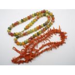 A rough coral bead necklace with yellow metal clasp,