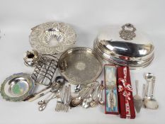 A collection of plated wares to include a cloche, tray, flatware and other.