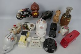 A collection of various money banks, predominantly ceramic, to include Wade.