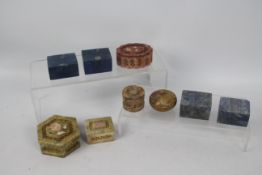 A collection of carved stone trinket boxes, largest approximately 3.5 cm x 7.5 cm.