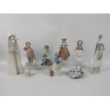 A collection of Spanish porcelain figures / groups by Lladro and Nao and a Lladro bell,