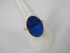 A lady's yellow metal (presumed 9 ct) dress ring set with a large synthetic blue stone,