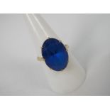 A lady's yellow metal (presumed 9 ct) dress ring set with a large synthetic blue stone,