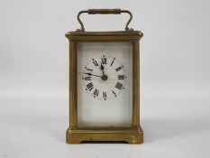 An early 20th century brass and glass cased carriage timepiece clock,