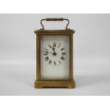 An early 20th century brass and glass cased carriage timepiece clock,