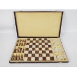 A carved stone chess set with 6.5 cm (h) king, contained in fitted box.