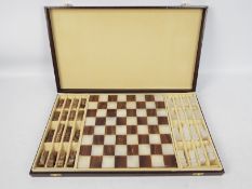 A carved stone chess set with 6.5 cm (h) king, contained in fitted box.